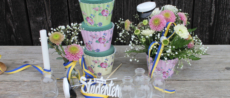 Blomsterarrangemang med cupcakes till studenten